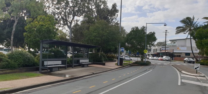 Covered bus stop near car park and pedestirian crossing