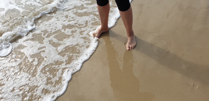 lower legs in the shallows at the beach