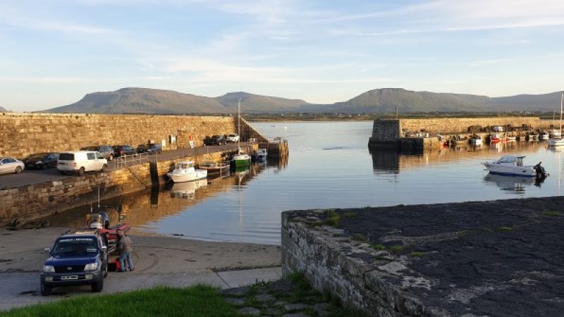Mullaghmore Harbour in the late afternoon with vessels and vehicles