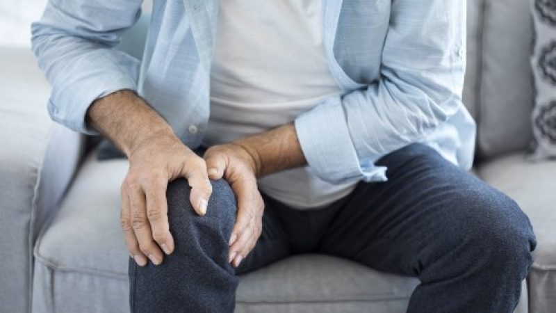 Man grasping painful knee