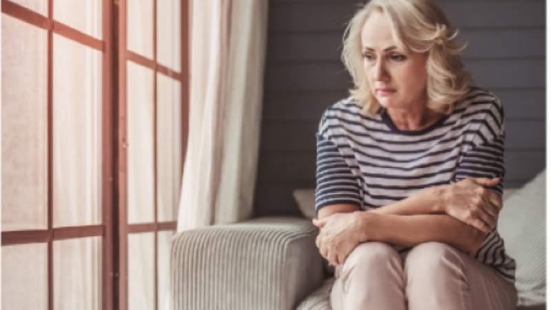 Woman sitting on a sofa feeling sad about movning house