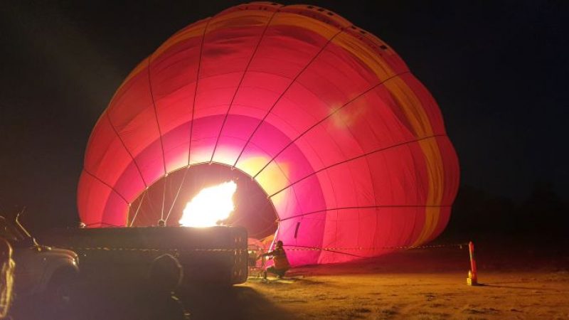 A hot air balloon being fired up ready for launching