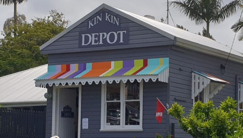 A weatherboard building with colourful details and a sign saying Kin Kin Depot