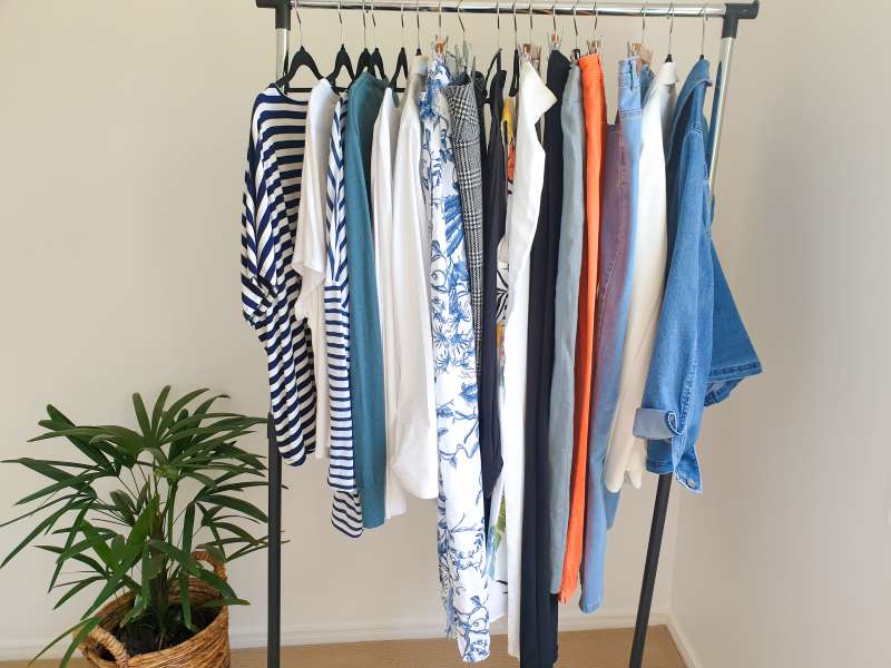 a rack of coordinated clothes for a capsule wardrobe