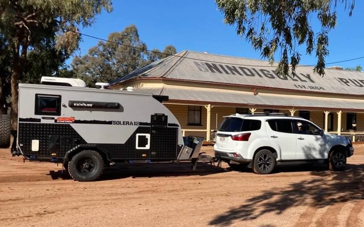 all the things that can go wrong the first time you buy a caravan or camper. Photo of people towing a van in red dirt