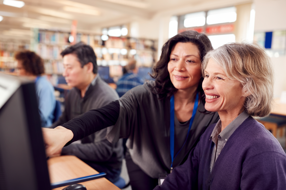Retiree being taught on computer - one of many things to do at the library